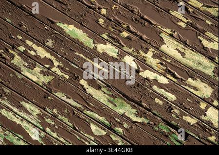Diagonal weathered wood planks with peeling brown and green paint, grunge timber texture, aged wooden background Stock Photo