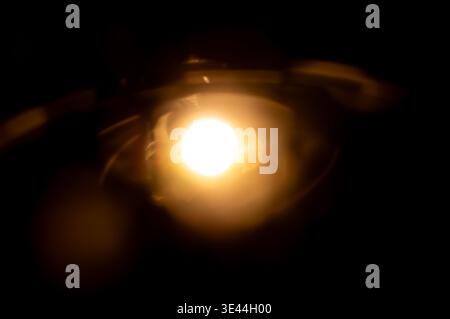 Abstract warm orange lens flare light overlay on black background, perfect for adding creative glare and bokeh effects to photos Stock Photo