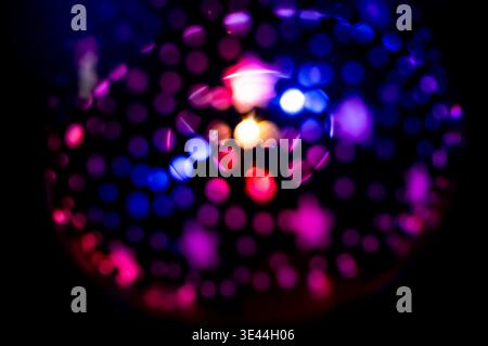 Abstract pattern of vibrant blue and magenta bokeh lights on a black background. Neon disco overlay. Creative photo effect Stock Photo