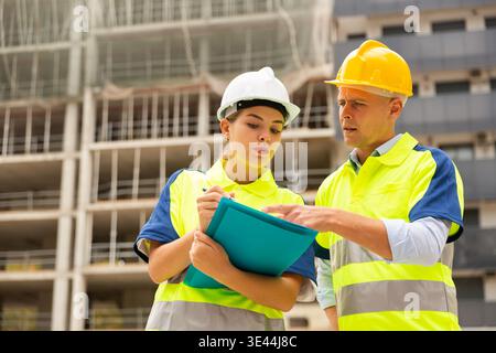 Two qualified engineers are discussing a construction plan Stock Photo