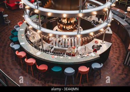 Deutschland, Hamburg: Barbereich TamTam im Hanseviertel, kein Tam-Tam in Hanseviertel, Gastroprobleme, zentrale runde Theke mit umlaufenden Lichtelementen und Flaschenregalen, zahlreiche Gläser und Weinflaschen vorbereitet, farbige Barhocker rund um die Theke, jedoch keine Gäste, komplett leerer Gastraum, sterile und ruhige Atmosphäre, keine Nutzung trotz ausgestatteter Infrastruktur, Innenraum wirkt gepflegt aber verwaist, Hinweis auf schwache Frequenz und wirtschaftliche Probleme im Einzelhandel und in der Gastronomie im innerstädtischen Bereich. *** Germany, Hamburg Bar area TamTam in Hanse Stock Photo