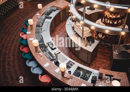 Deutschland, Hamburg: Barbereich TamTam im Hanseviertel, kein Tam-Tam in Hanseviertel, Gastroprobleme, zentrale runde Theke mit umlaufenden Lichtelementen und Flaschenregalen, zahlreiche Gläser und Weinflaschen vorbereitet, farbige Barhocker rund um die Theke, jedoch keine Gäste, komplett leerer Gastraum, sterile und ruhige Atmosphäre, keine Nutzung trotz ausgestatteter Infrastruktur, Innenraum wirkt gepflegt aber verwaist, Hinweis auf schwache Frequenz und wirtschaftliche Probleme im Einzelhandel und in der Gastronomie im innerstädtischen Bereich. *** Germany, Hamburg Bar area TamTam in Hanse Stock Photo