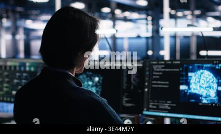 Data center system administrator working on artificial intelligence neural network software development. Server room IT specialist implementing machine learning technology in workplace, camera A Stock Photo