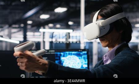 Data center engineer using virtual reality, working on neural network software development. IT expert in server room using VR equipment, implementing machine learning technology, camera A Stock Photo