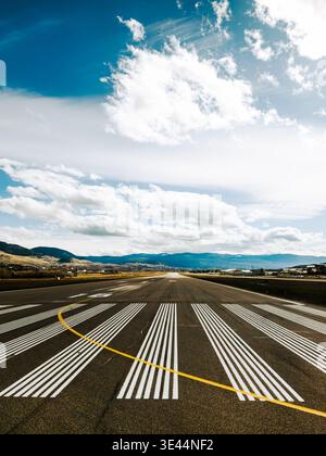 Empty runway at a small airport on a vibrant early spring day taken from a passenger window on a plane Stock Photo