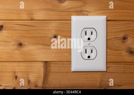 A electrical outlet on a wood wall. Stock Photo