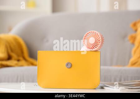 Bag with mini fan on table in room, closeup Stock Photo