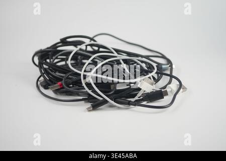 Various tangled cables are scattered on a white background Stock Photo