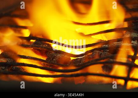 Fire burns on a grill during a summer cookout Stock Photo