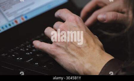 Hands typing on a laptop, performing data entry or programming work in Moscow Stock Photo
