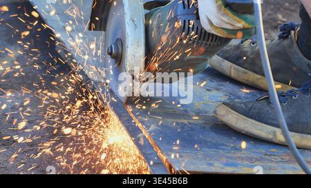 Worker cutting metal using an angle grinder, producing sparks in Moscow Stock Photo