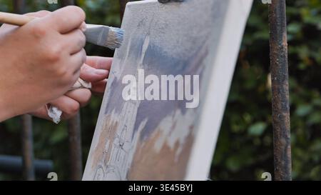 Artist painting Moscow cityscape outdoors with a brush on a canvas Stock Photo