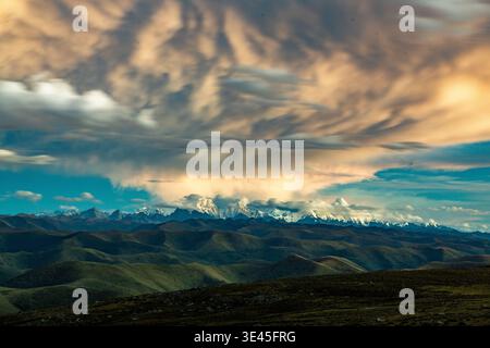 Dramatic cloud formations gather above the snow-covered peaks of Mount Gongga (Minya Konka) in Sichuan, China. Stock Photo
