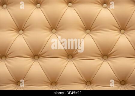 Beige tufted leather texture with buttons creating a luxury upholstery background pattern Stock Photo