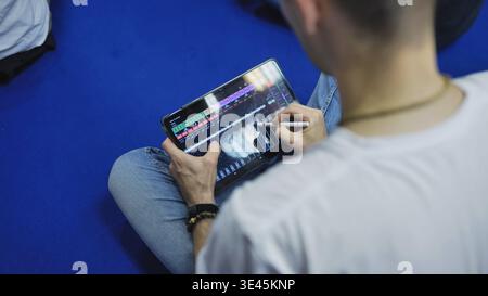 Man using stylus on a tablet, working with a digital audio workstation Stock Photo