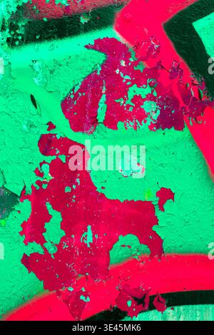 Peeling Graffiti Paint on Urban Concrete Wall in Green and Magenta Stock Photo