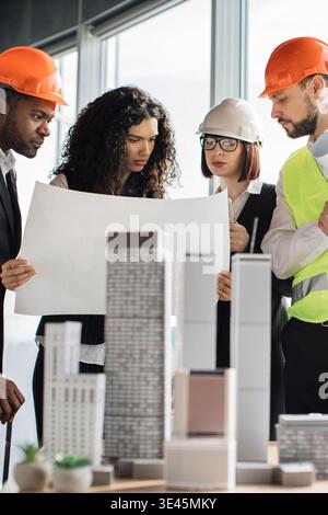 Construction Team Reviewing Blueprints Stock Photo