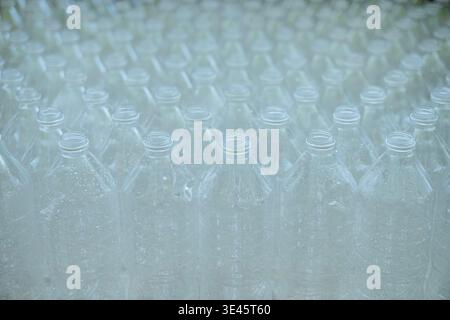 Several empty clear plastic bottles with no caps were stacked in a row. Stock Photo