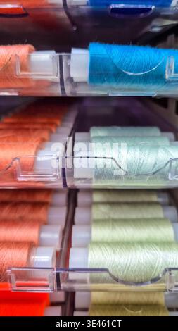 Sewing threads organized in plastic box, colorful spools close up. Concept: sewing supplies storage Stock Photo