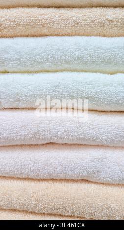 Stack of clean towels on shelf, soft neutral texture. Concept: home laundry routine Stock Photo
