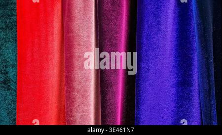 Velvet fabric rolls arranged in rows, rich color texture close up. Concept: upholstery fabric selection Stock Photo