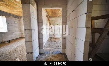 New house construction interior showing raw walls and wooden ceiling Stock Photo