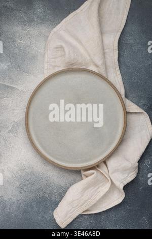 empty grey plate and linen napkin on grey concrete or stone table. Cooking background. Rustic style. Selective focus. Top view, copy space Stock Photo