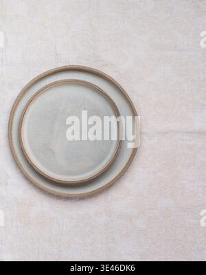 empty grey plates and linen napkin on grey concrete or stone table. Cooking background. Rustic style. Selective focus. Top view, copy space Stock Photo