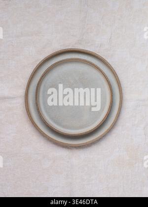 empty grey plates and linen napkin on grey concrete or stone table. Cooking background. Rustic style. Selective focus. Top view, copy space Stock Photo