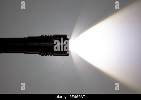 A spotlight on the wall. A torch with a ray of light. Flashlight. Black torch lights with copy space. Stock Photo