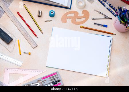 Blank spiral notebook with geometry drafting tools background. Various drawing instruments for school or engineering. Desk top view copy space Stock Photo