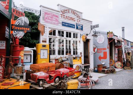 Burkes Pass, New Zealand: Vintage petrol pumps, retro enamel signs, and old pedal cars outside Three Creeks Trading Co storefront in South Island. Stock Photo