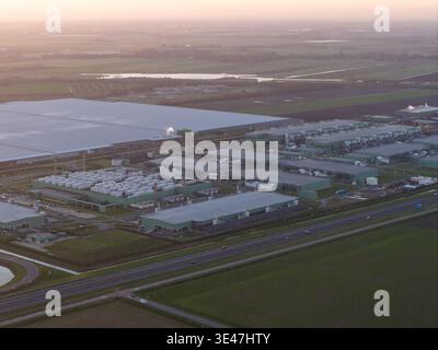 Aerial view of large data center campus facility surrounded by green fields during an aerial view at dawn, representing modern technology infrastructu Stock Photo