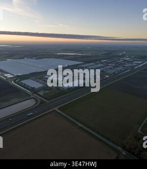 Aerial view of large data center facility with multiple buildings, cooling units, and surrounding infrastructure connecting global internet, Middenmee Stock Photo