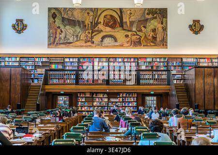 The first reading room at the German National Library in Leipzig, featuring green reading lamps and a green linoleum work surface. The walls are adorned with frescoes depicting Late Nazarene motifs. Leipzig, Saxony, Germany Stock Photo