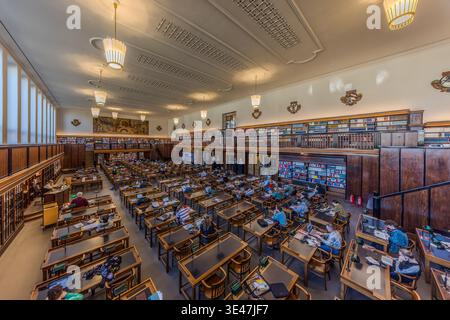 The first reading room at the German National Library in Leipzig, featuring green reading lamps and a green linoleum work surface. The walls are adorned with frescoes depicting Late Nazarene motifs. Leipzig, Saxony, Germany Stock Photo