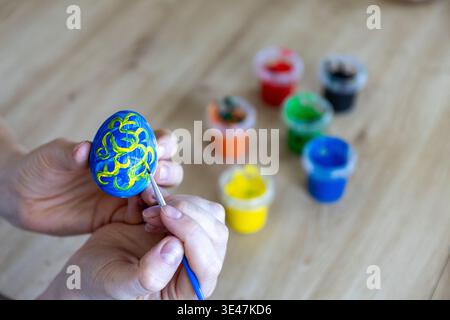 Woman is painting eggs preparing for Easter.  Stock Photo