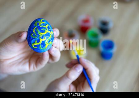 Woman is painting eggs preparing for Easter.  Stock Photo