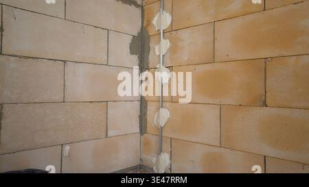 Corner of a block wall during house construction with plaster guides. Stock Photo