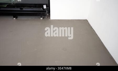 Self leveling screed floor with footprints in a room under construction. Stock Photo