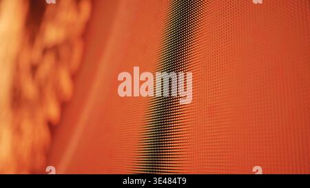 LED screen pixels creating modern digital display with abstract orange red light Stock Photo