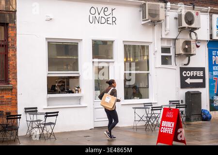 LONDON - FEBRUARY 2, 2026: Over Under cafe exterior with customer and A-frame sign on Earl's Court street Stock Photo