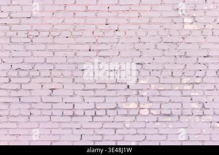 Painted dirty pink brick wall. Old shabby brickwork dusty rose color Stock Photo