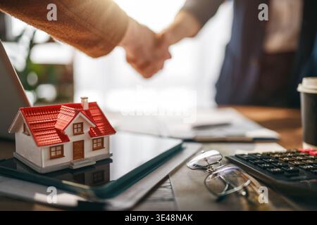 Inspiring conceptual image of a successful real estate transaction, showcasing a handshake between two individuals agreeing on a home purchase deal. T Stock Photo