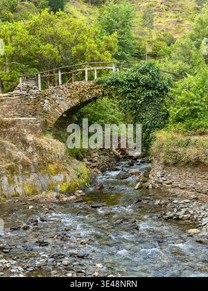 Ancient Rounded Stone Aerial view of an ancient stone bridge spanning a rocky stream in the ...