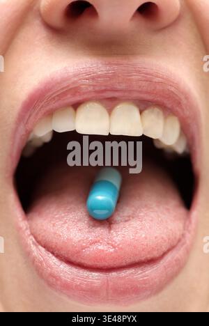 Young Woman Swallowing a Medicine Capsule, Close Up Stock Photo