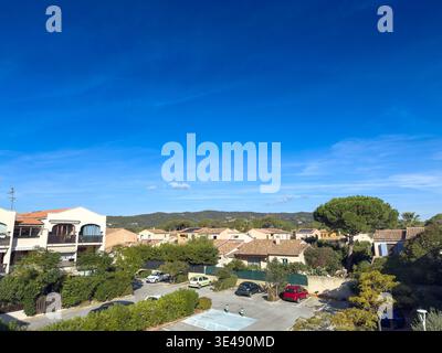 French suburban district in the Cote dAzur region with single family homes, parked cars, gardens and low density residential development under a brigh Stock Photo
