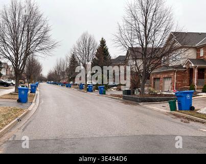 March 26, 2026 - Aurora, Ontario, Canada: Garbage day scene with extra large blue recycling bins and green organic waste bins lined up at the curb on Stock Photo
