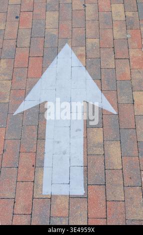 An arrow painted on the sidewalk or path Stock Photo