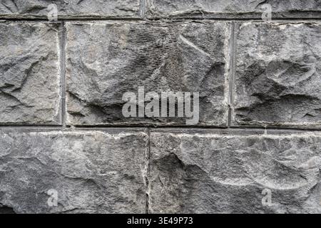 Rough cut stone blocks forming an old gray wall with visible texture and mortar lines Stock Photo